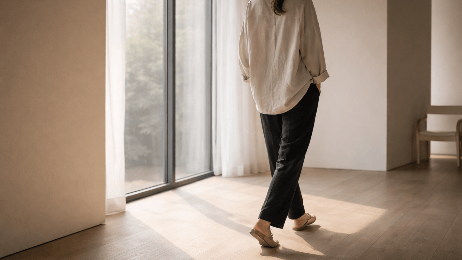 person walking slowly near a window in a calm indoor space representing mental reset and forward movement