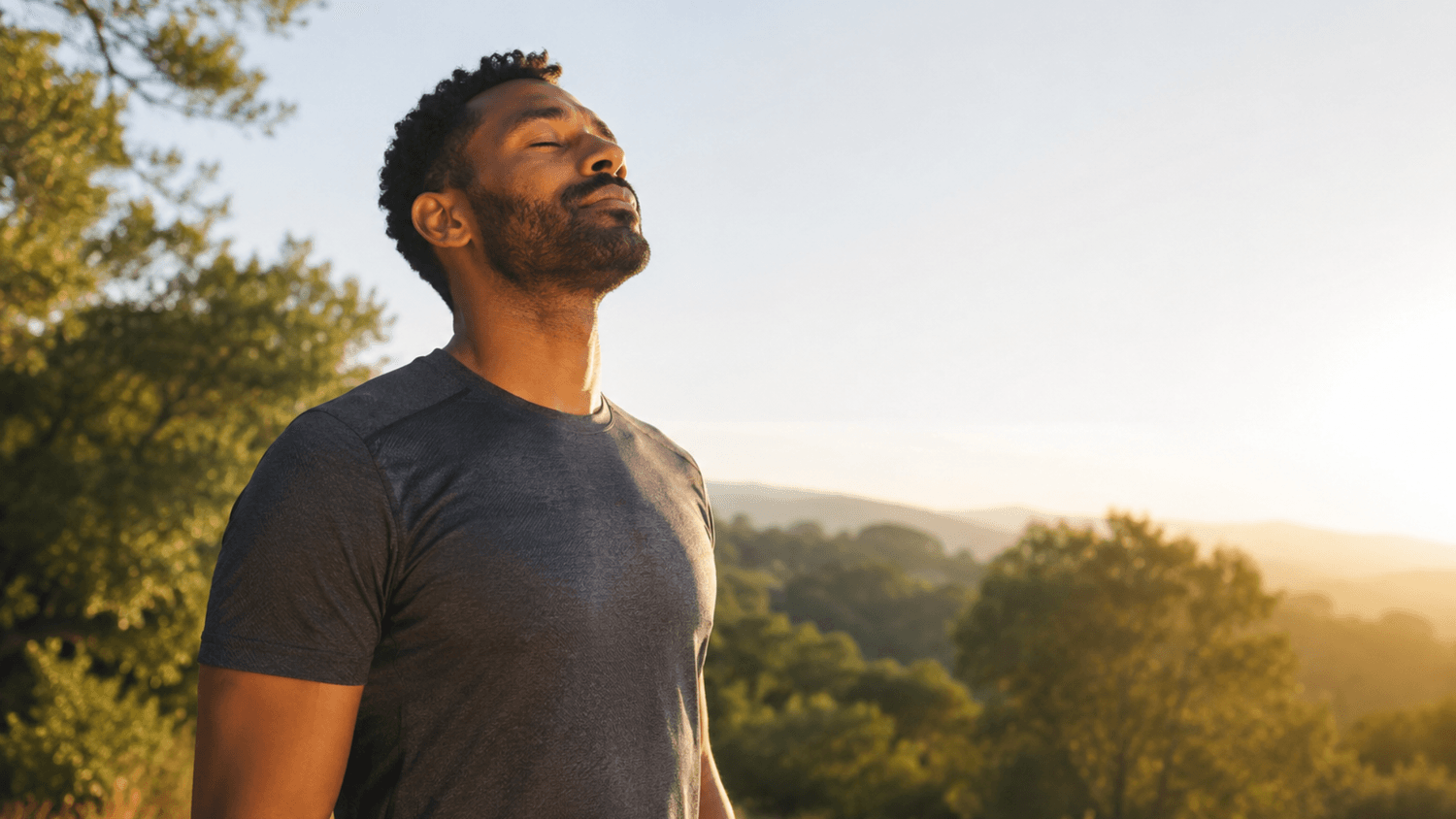 Person taking a slow, calming breath outdoors in warm morning sunlight.