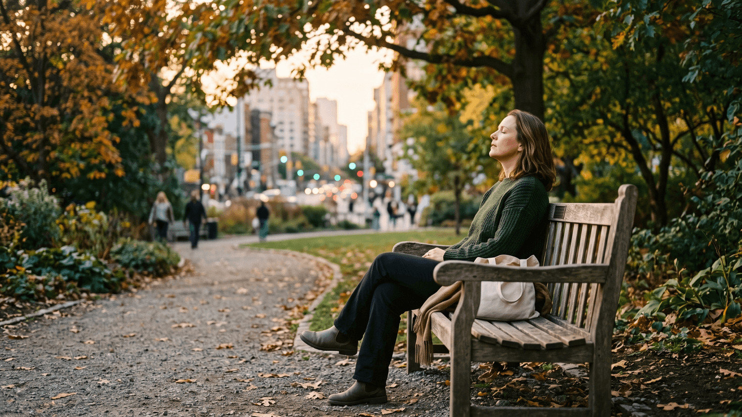 Adult relaxing their shoulders and taking a slow breath while sitting on a quiet park bench.