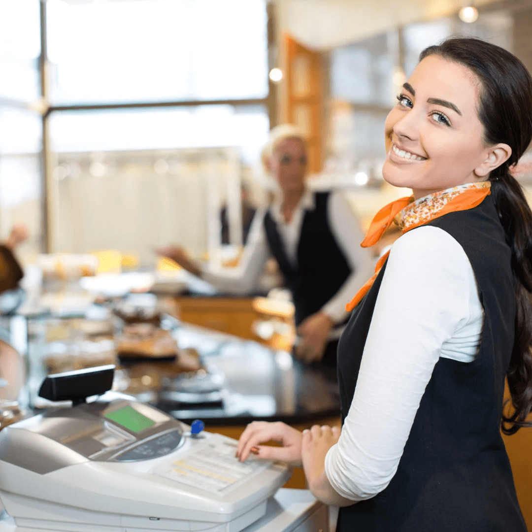 Retail Sales Success ebook cover – your complete guide to mastering retail sales skills, customer interactions, and sales growth a woman at the cash register smiling