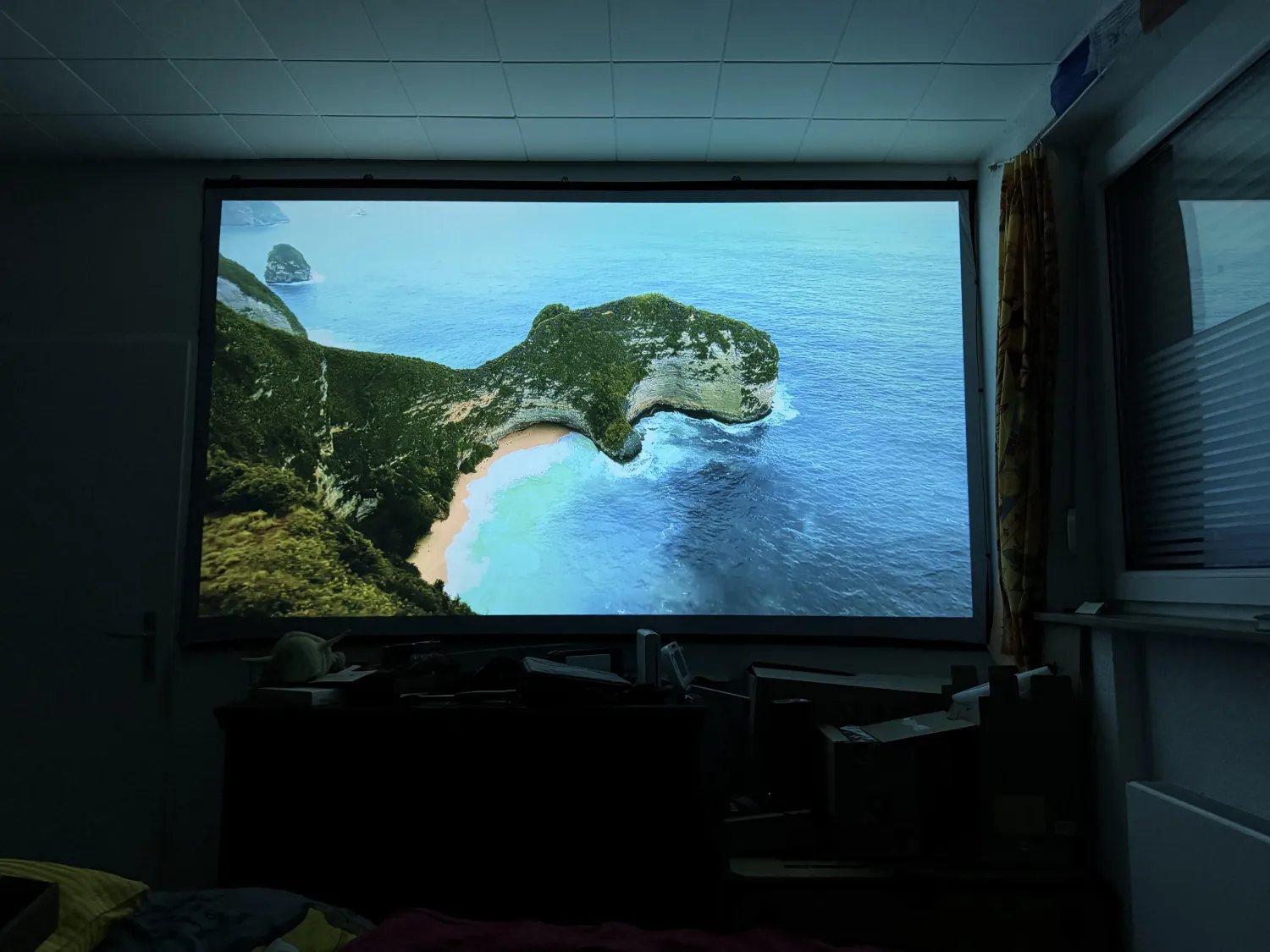 LuminaPro projector in bedroom showing massive cinematic screen on wall