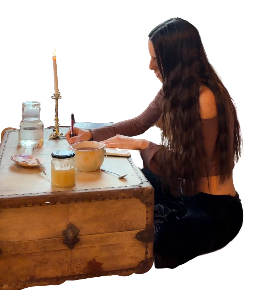 Merlina Seijas escribiendo en su escritorio, con una vela y un frasco de miel