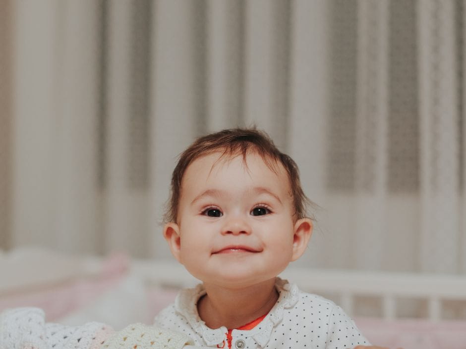 Bébé souriant dans son lit