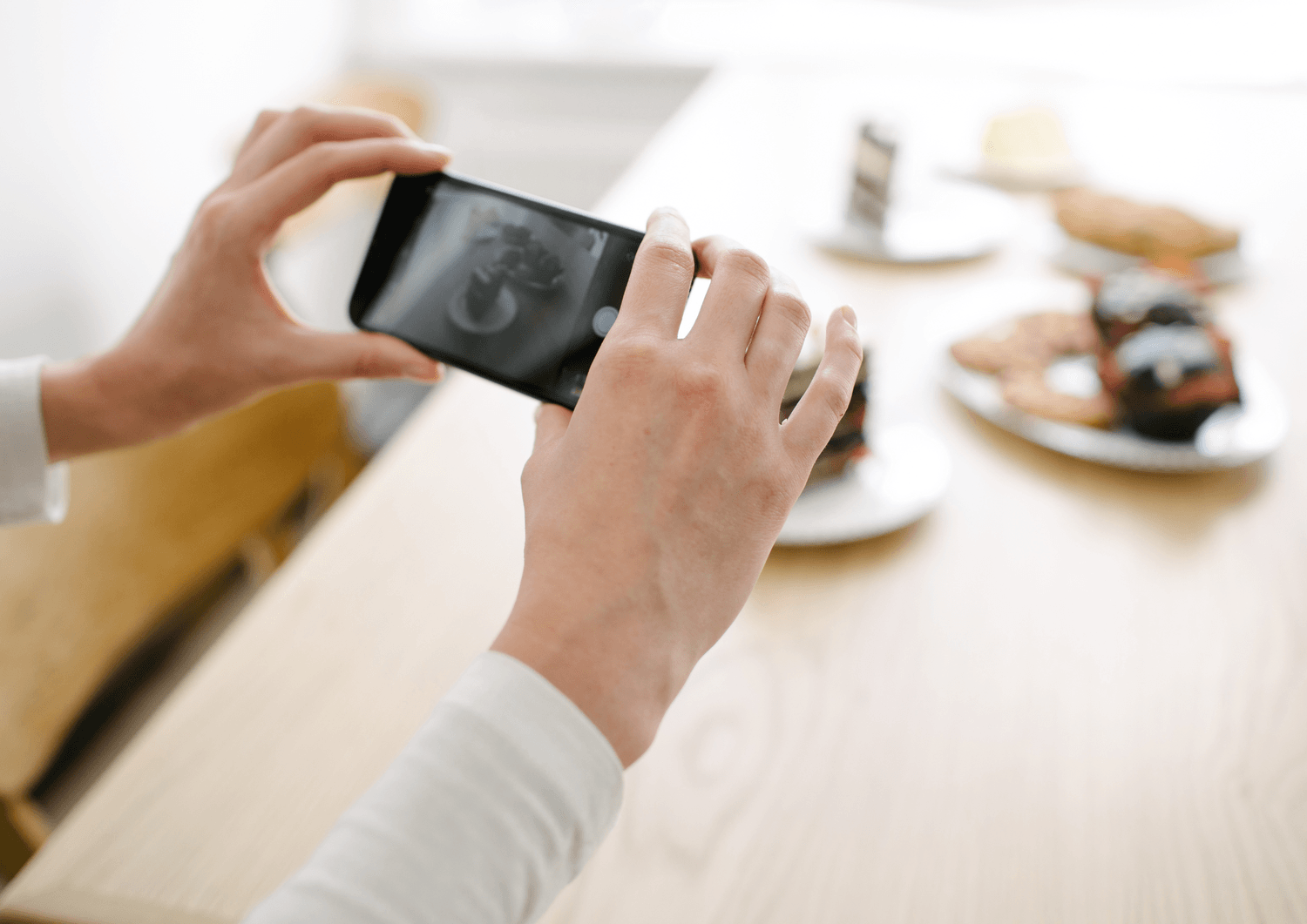 Person som fotograferer mat med smarttelefon – illustrerer innholdsproduksjon og visuelt innhold for sosiale medier