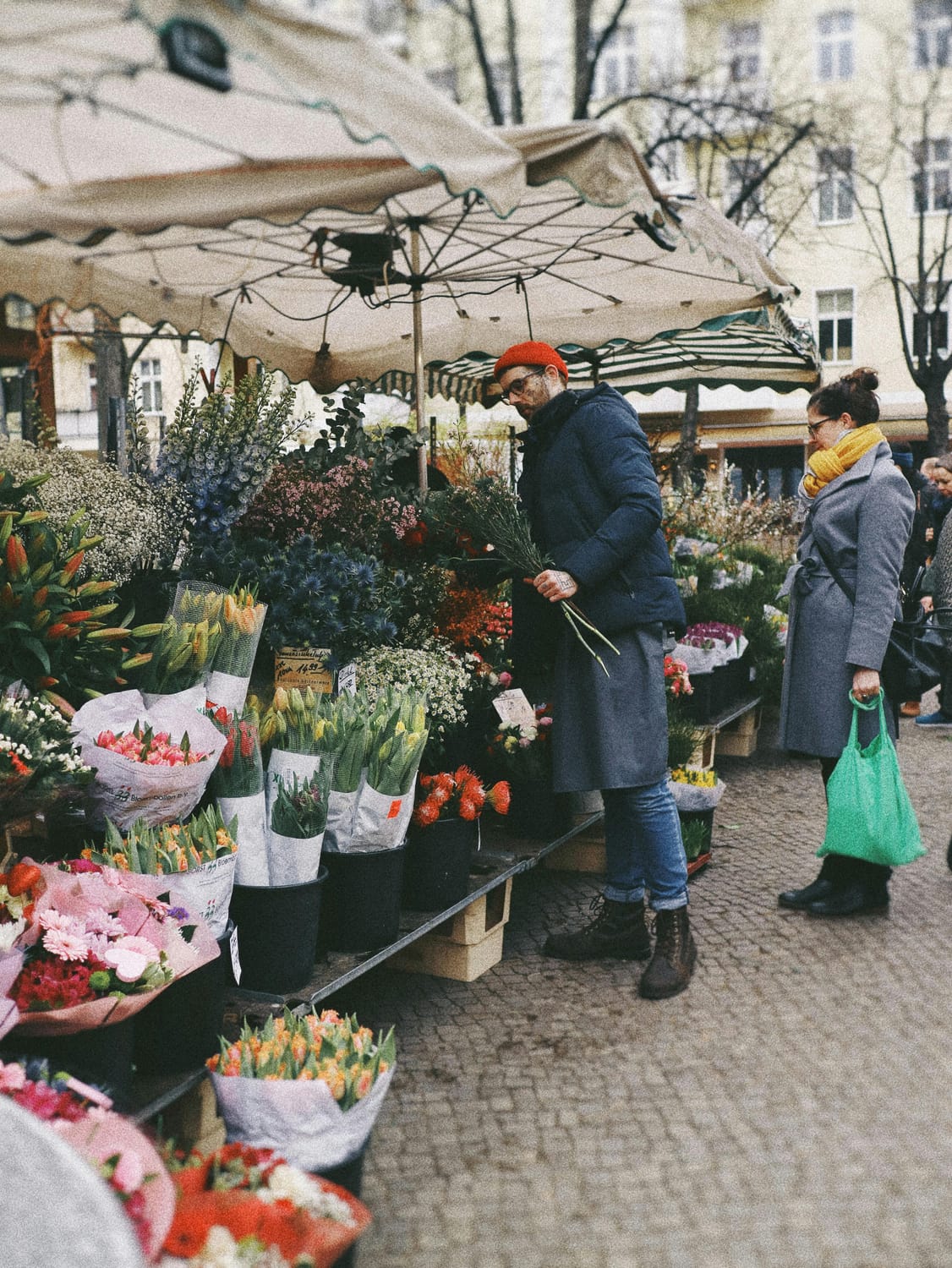 Woman with shopkeeper at local outdoor flower market
