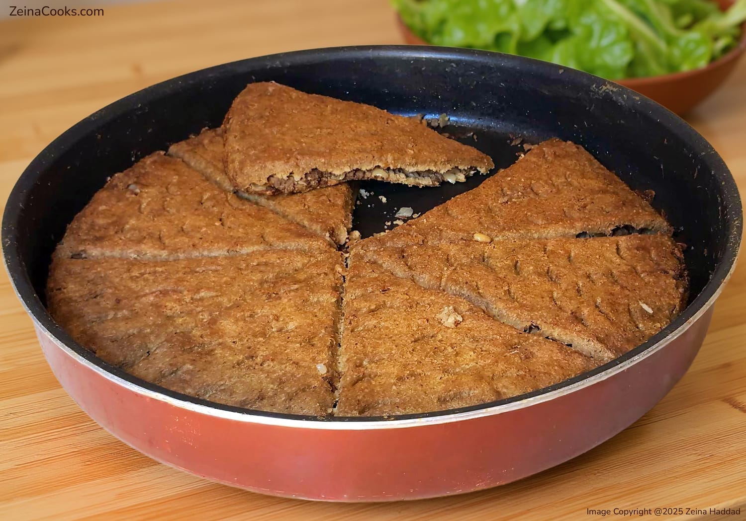 Close up texture of authentic Lebanese Kibbeh Bake cut open to show the savory Hashweh (spiced meat) filling and thin crispy bulgur layers from the 'Main Dishes and Desserts' cookbook by Zeina Haddad