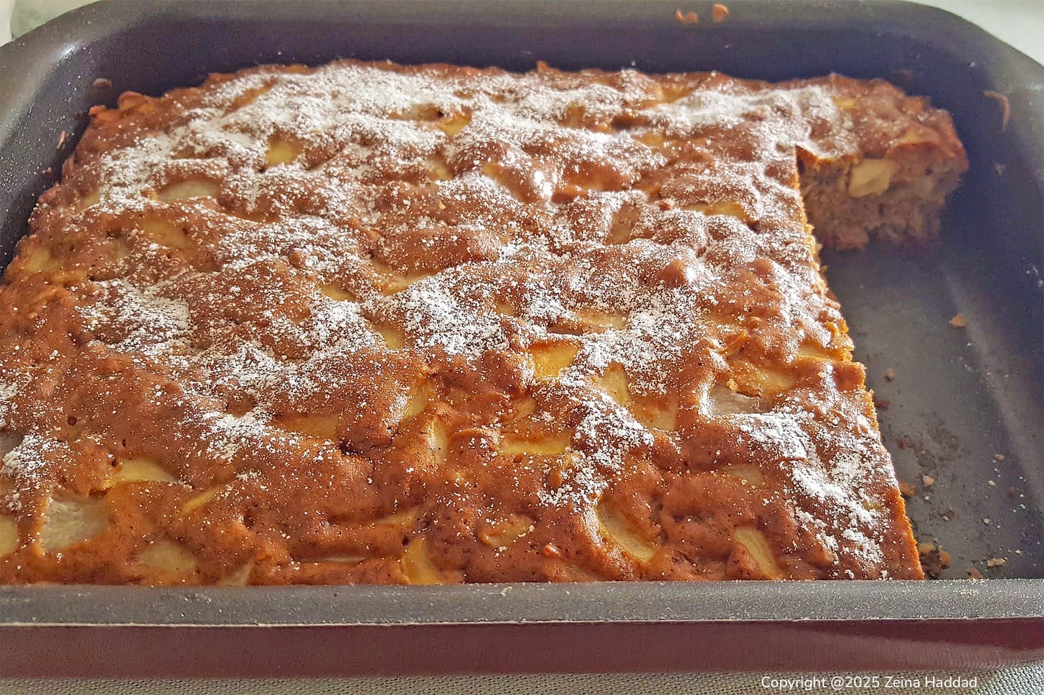 Apple walnut cake in a baking pan by ZeinaCooks.com