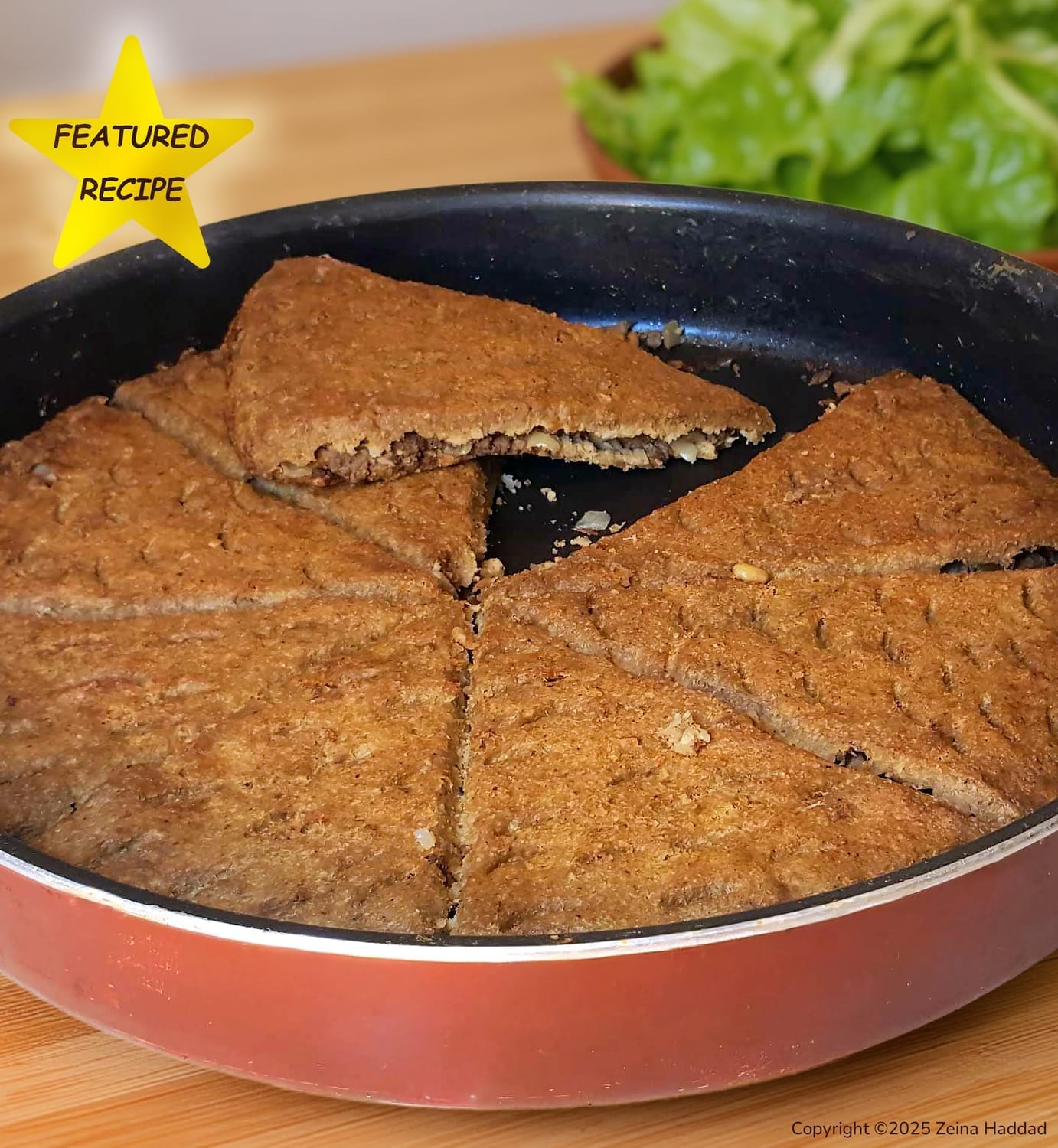 Golden brown authentic Lebanese Kibbeh bake in a round pan. A traditional savory meat and bulgur appetizer from the 'Main Dishes and Desserts' cookbook by Zeina Haddad.