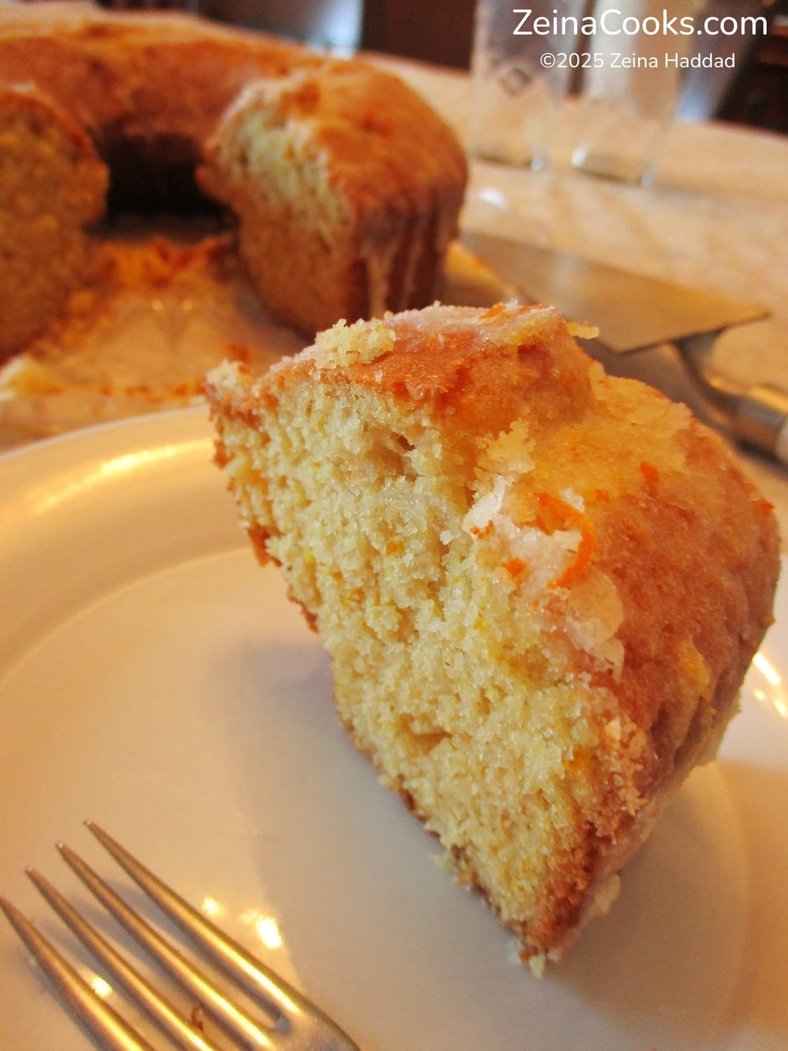 A close-up on a slice of glazed Moroccan Orange Cake showing a moist and soft crumb, by ZeinaCooks.com.