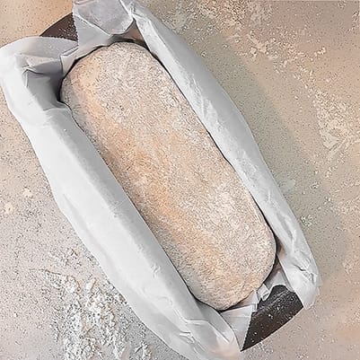 The dough for the 50/50 bread loaf. shaped into a loaf and rolled in flour, placed in a loaf pan ahead of the 2nd rise, by ZeinaCooks.com.