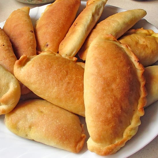 A platter of golden-brown Lebanese meat pies (Fatayer bi Lahmeh).
