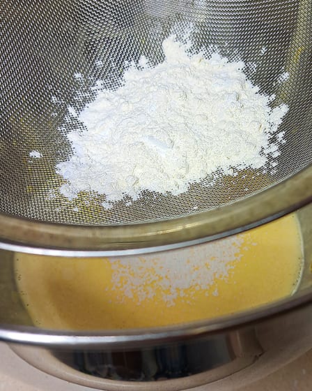 sifting the flour into the egg yolks