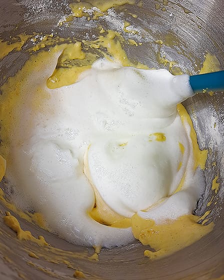 folding the beaten egg whites into the yolk and flour mixture