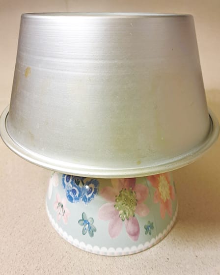 The tube pan after baking inverted on an upside down bowl