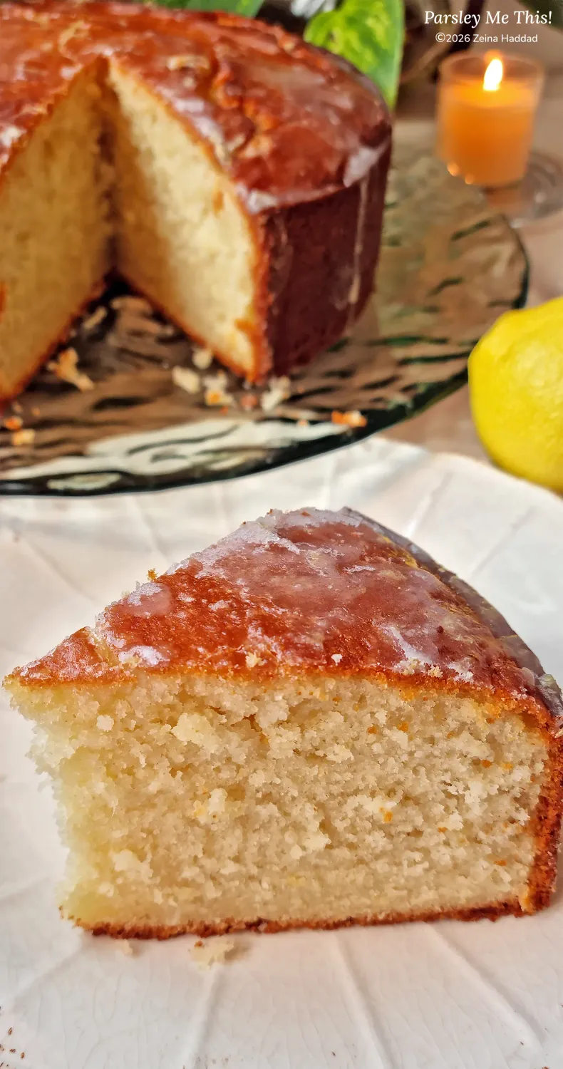 A close-up on slice of lemon butter cake showing the soft, moist crumb, by parsley me this (ZeinaCooks.com).