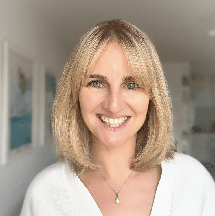 Picture of laura thain, blonde hair, white cardigan, smiling to camera,