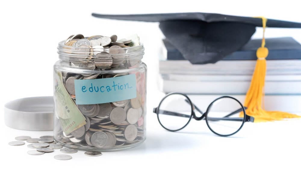 Jar labeled education savings with coins