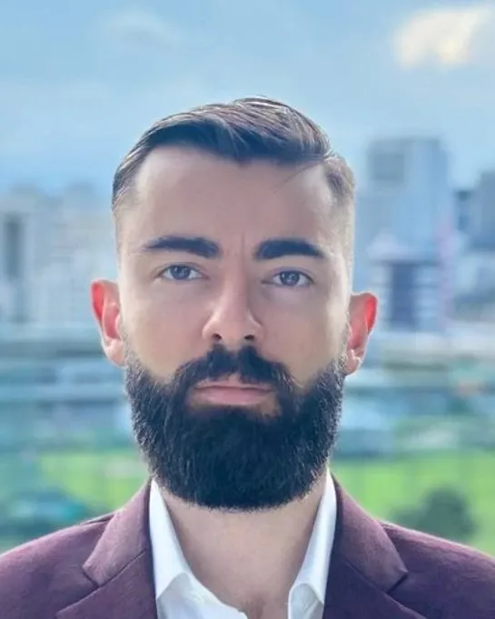 Valentin Kuznetcov, fractional CFO and Chief Growth Officer, photographed outdoors against a city skyline.