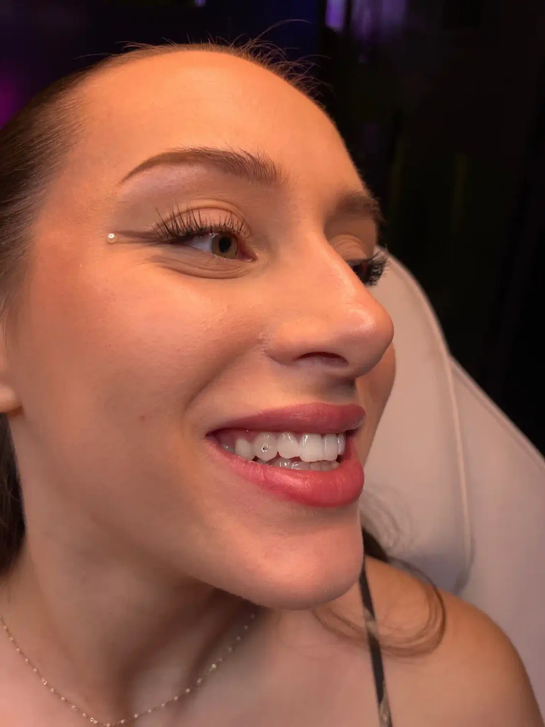 Cliente heureuse après la pose d'un strass dentaire réalisé par Beauty By Besse