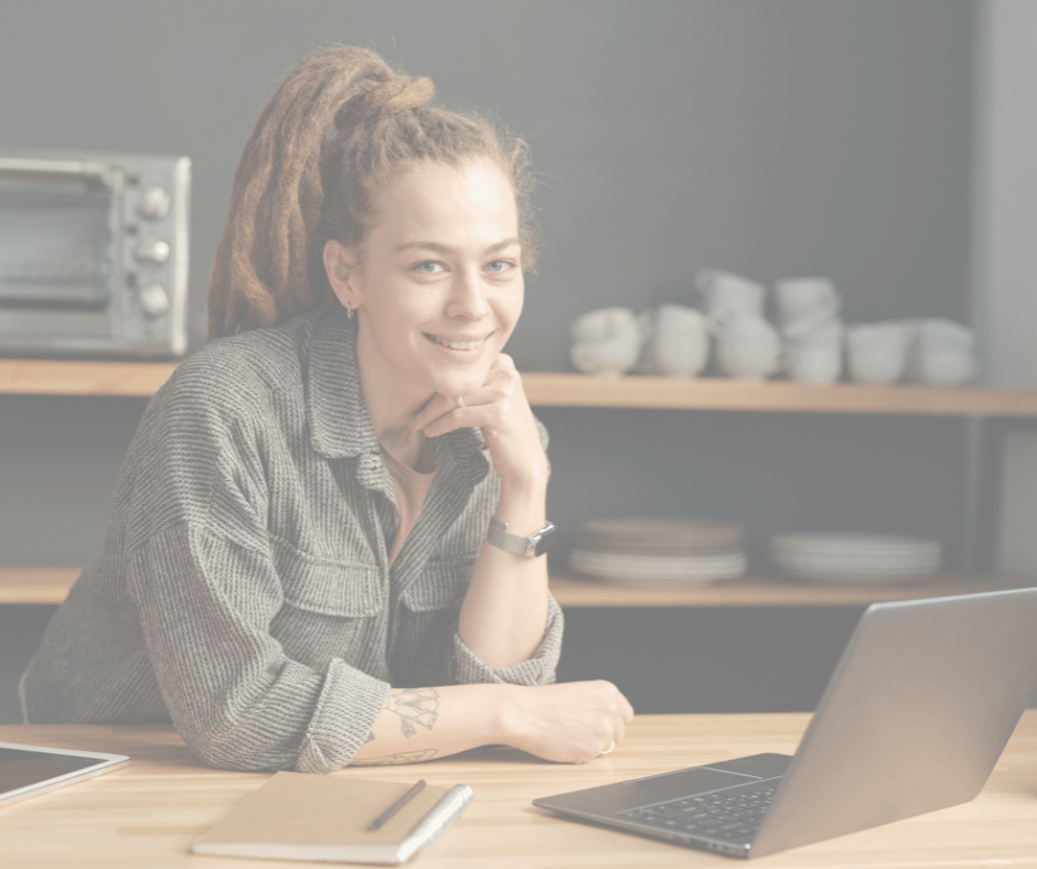 Young South African woman smiling at her laptop while working on starting her online business from home.