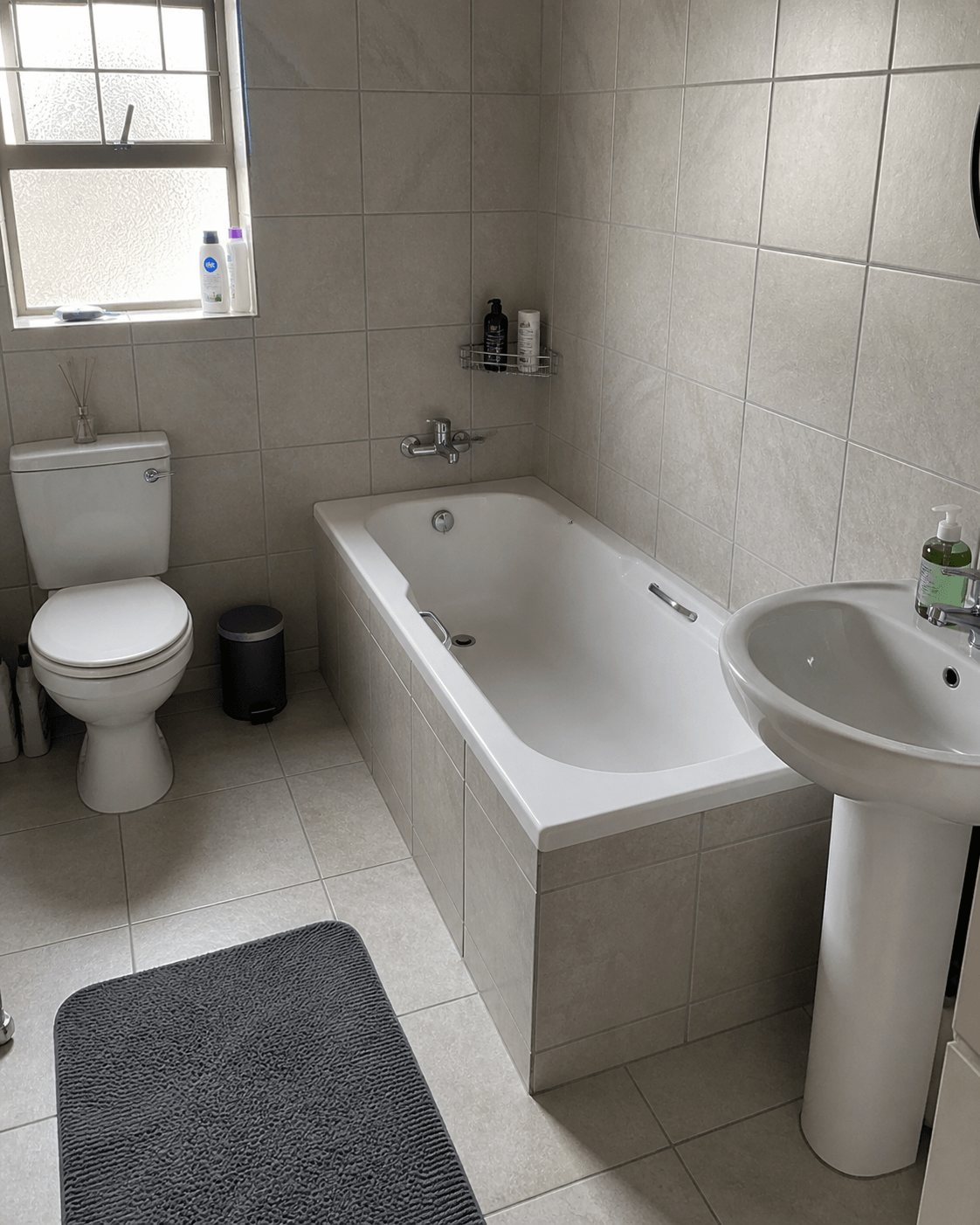 Bathroom retiling project with clean grout lines and modern tiles Updated bathroom renovation with new tiles and fixtures Small bathroom remodel with fresh tiling and neat finish Residential bathroom retiling completed in Durban home Modern bathroom upgrade with neutral tiles and clean installation