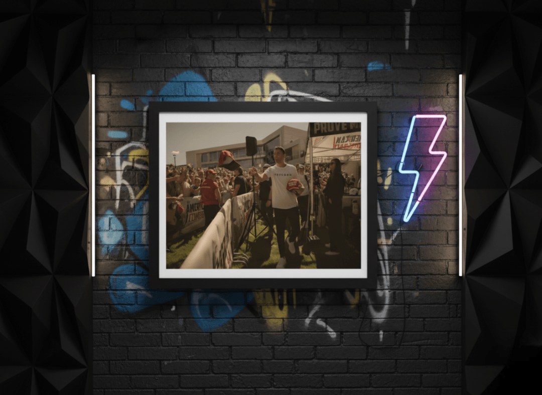 A framed picture on a modern wooden desk next to a laptop.