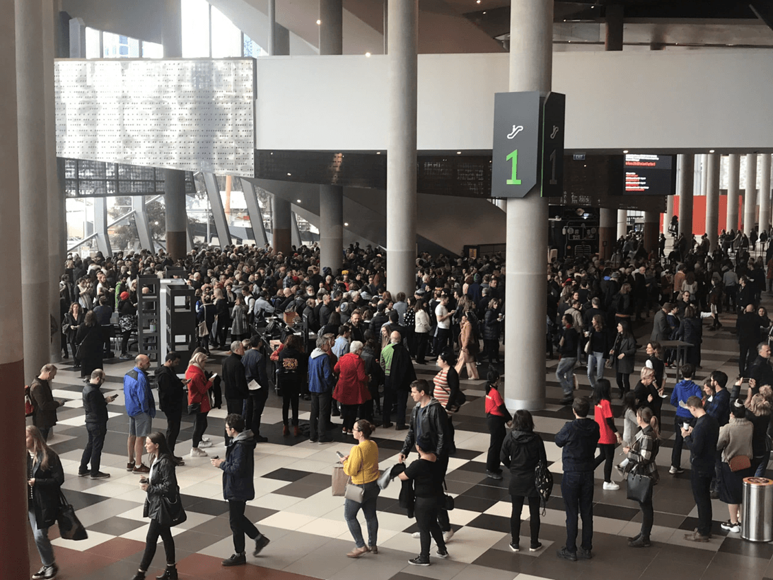 A large queue of people in a venue waiting to be seated