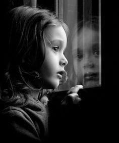 Niña interior sentada en un rincón iluminado representando la herida de abandono y el proceso de sanación emocional.