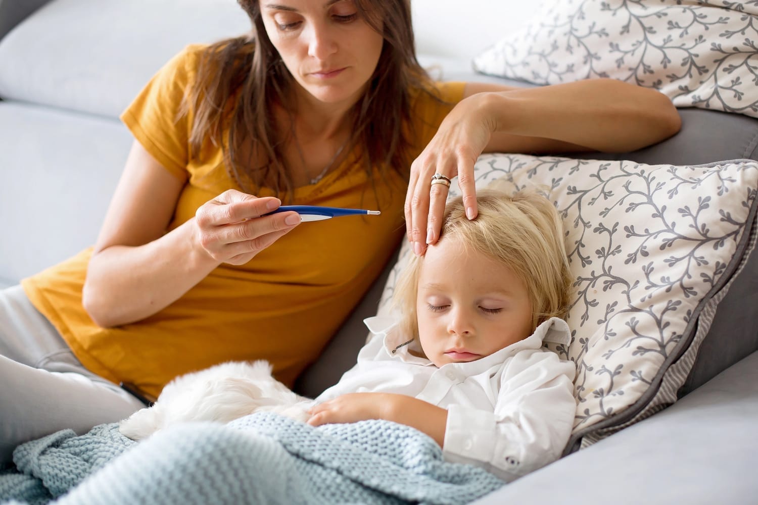 Man giving Reiki to a pregnant woman who is lying on a yoga mat on the floor
