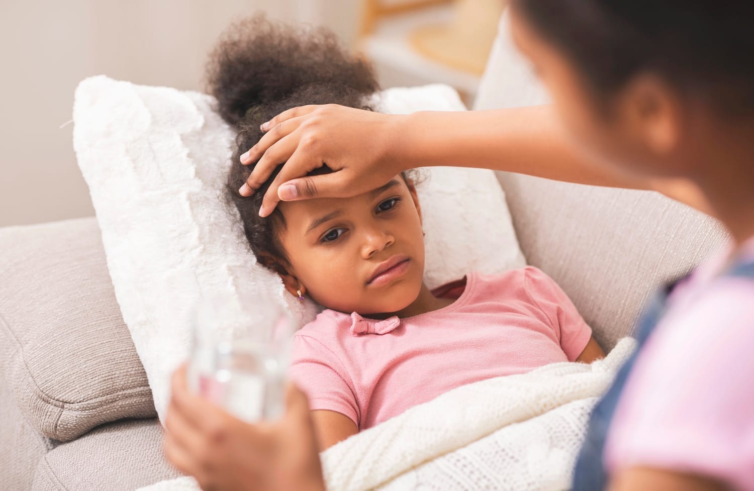 Man giving Reiki to a pregnant woman who is lying on a yoga mat on the floor