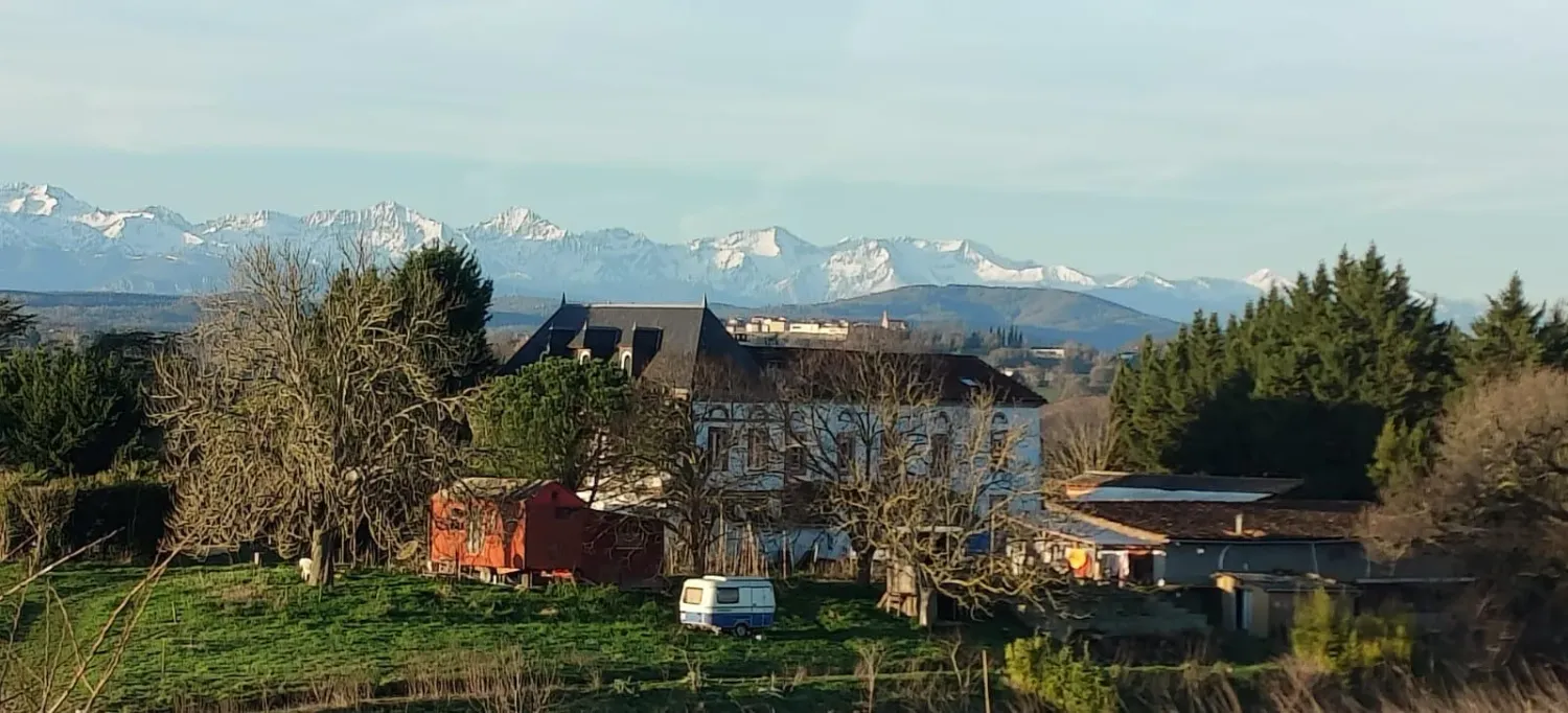 La maison de l'écovillage de Pourgues en hiver, face aux Pyrénées enneigées