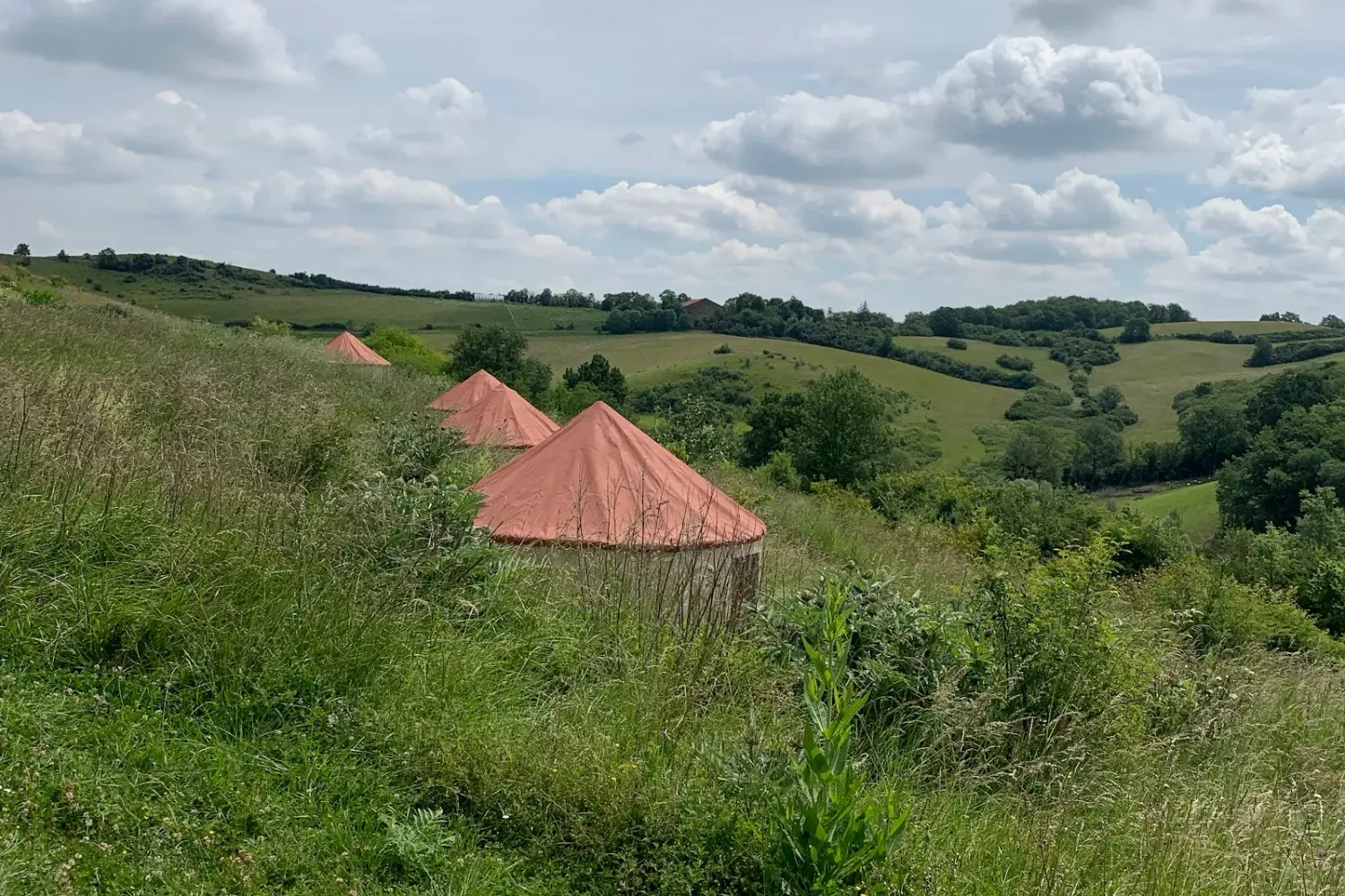 Yourtes au toit orange dans les collines de l'écovillage de Pourgues, en Ariège