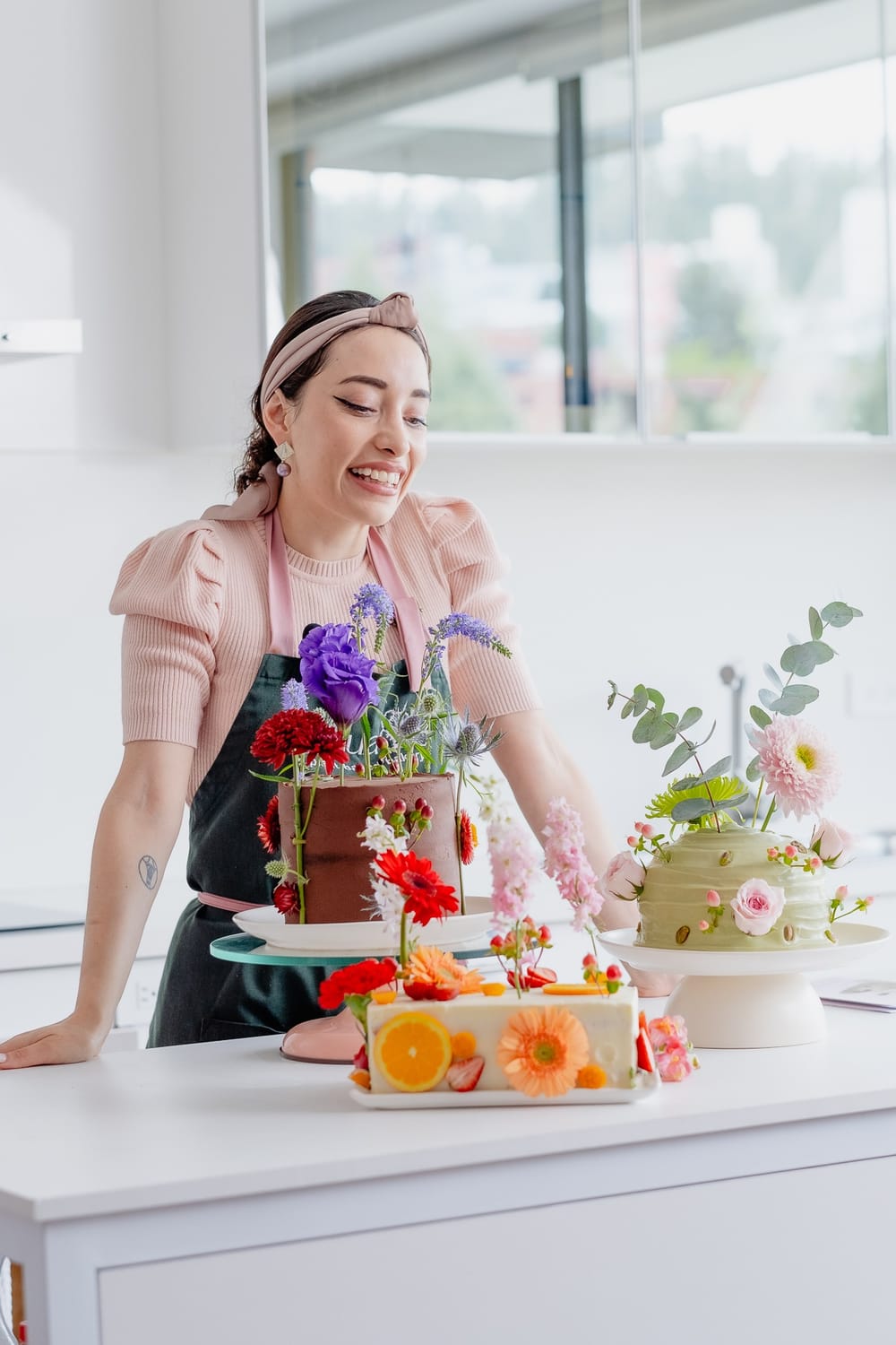 Paola Morocho junto a los tres pasteles del recetario