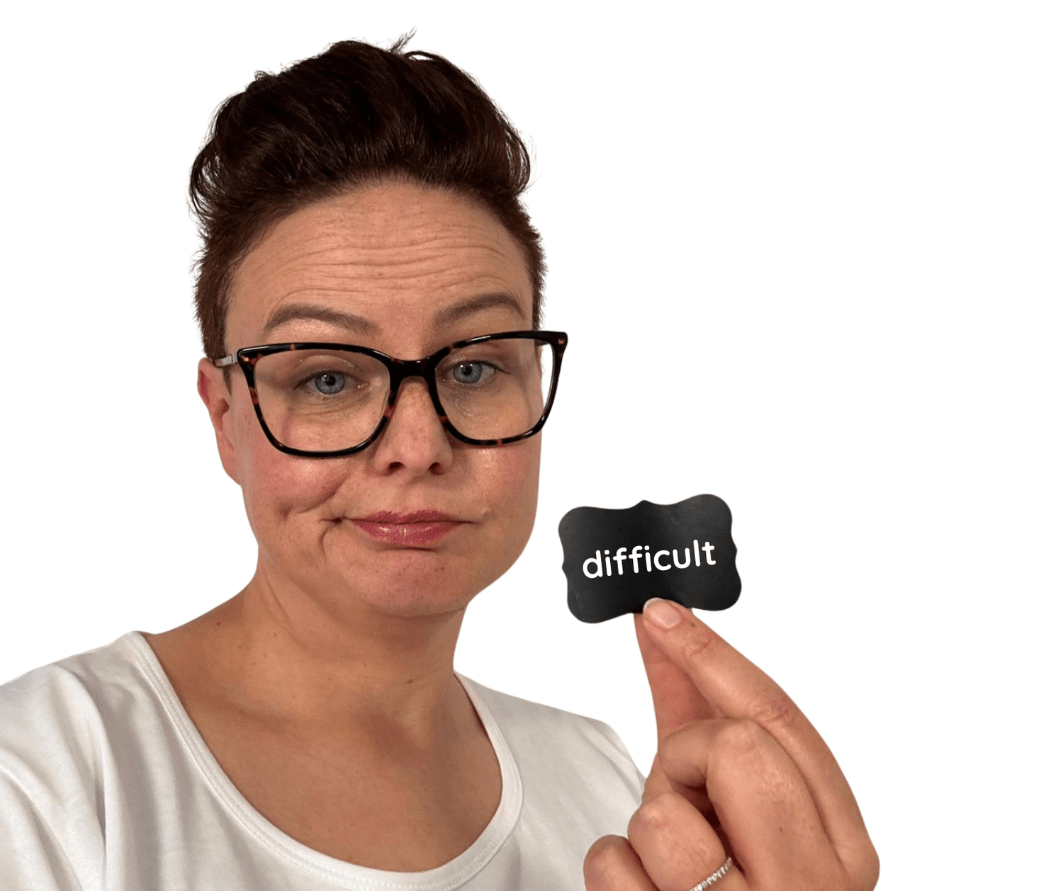 A photo of freya corboy the founder of mumshine www.mumshine.com.au a neuroaffirming counselling and coaching practice dedicated to supporting neurodivergent mums. Freya is looking at the camera with an eyebrow raised holding a label saying "difficult"