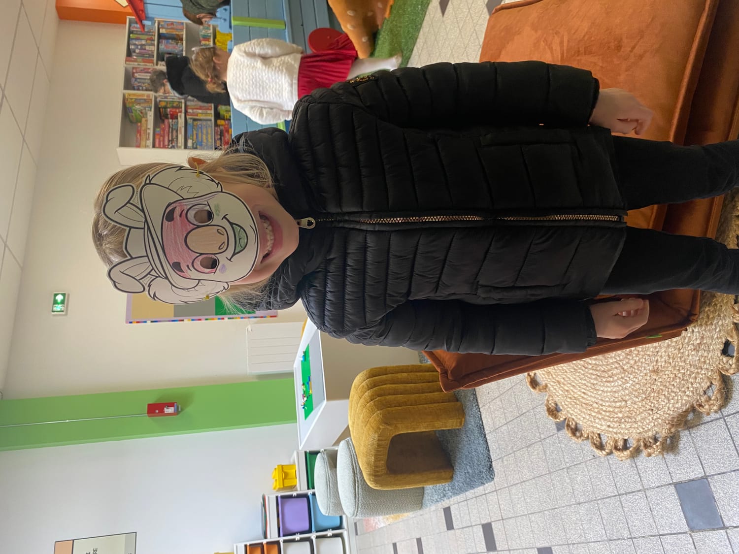 Enfants à la ludothèque de Coudekerque-Branche, coloriant avec application des masques de Pâques représentant le koala Mini Explorers avec des oreilles de lapin.