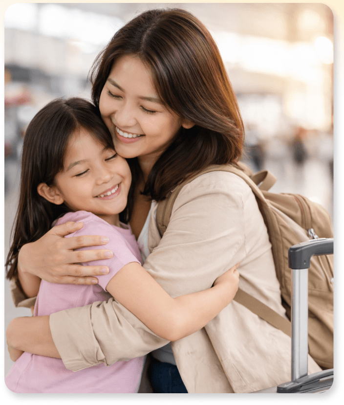 Young Filipino family smiling outdoors, child on dad’s shoulders, mom hugging. Love and security.