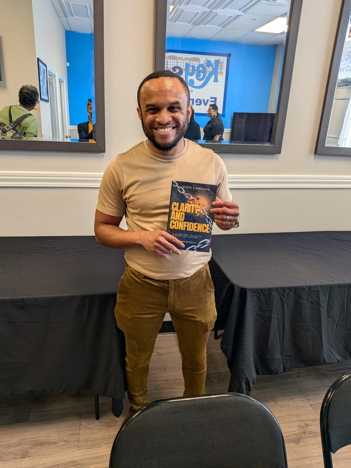 An event attendee holding a copy of Clarity and Confidence