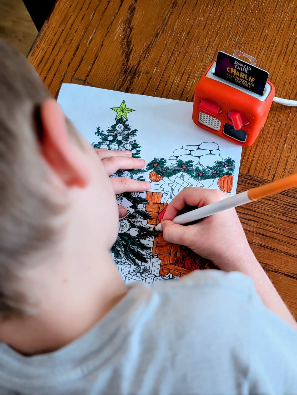 Active boy coloring while listening to audiobooks for homeschool focus.