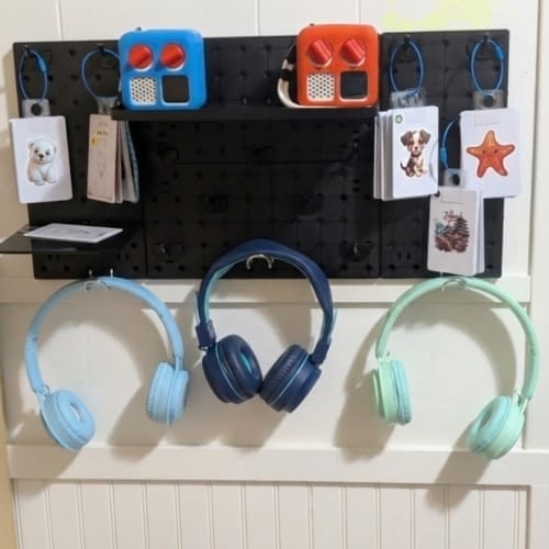 DIY Yoto player storage and headphone organization on pegboard wall.