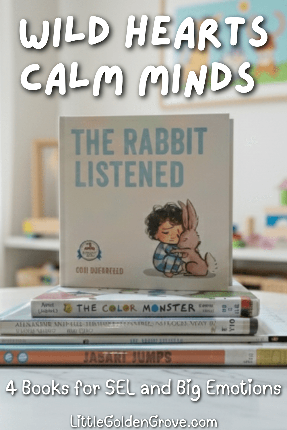 A stack of children's social emotional learning books including The Color Monster and Jabari Jumps on a white marble table with a "Wild Hearts, Calm Minds" text overlay