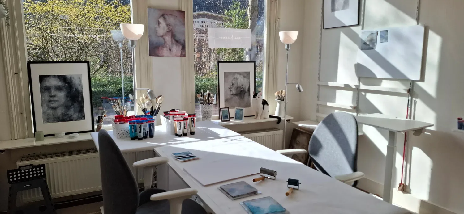 Ingelijste monoprints op de werktafel in het atelier