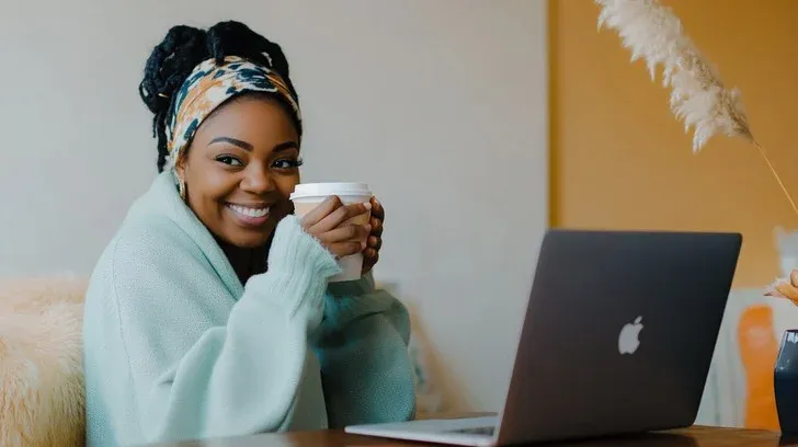 attractive black female entrepreneur with coffee and laptop