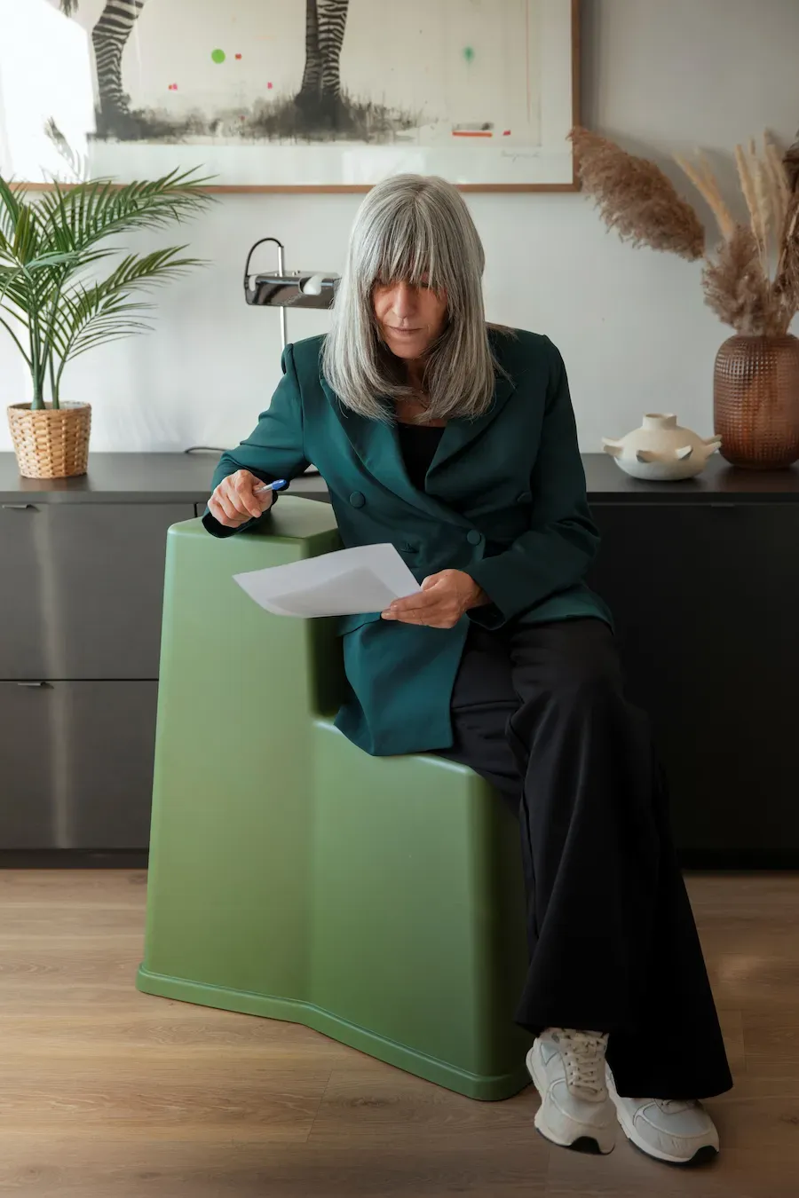 Designer de interiores a analisar projeto de decoração residencial, avaliando soluções de espaço, funcionalidade e conforto.