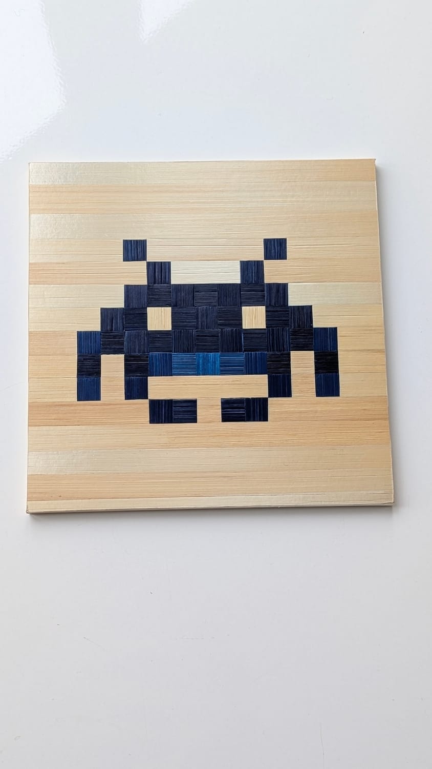 tableau mural pixel art en marqueterie de paille, space invader bleu