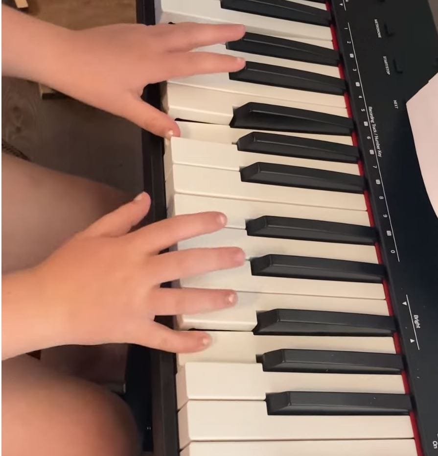 Student playing chords on gifted keyboard at Sounds of Joy Music Studio.