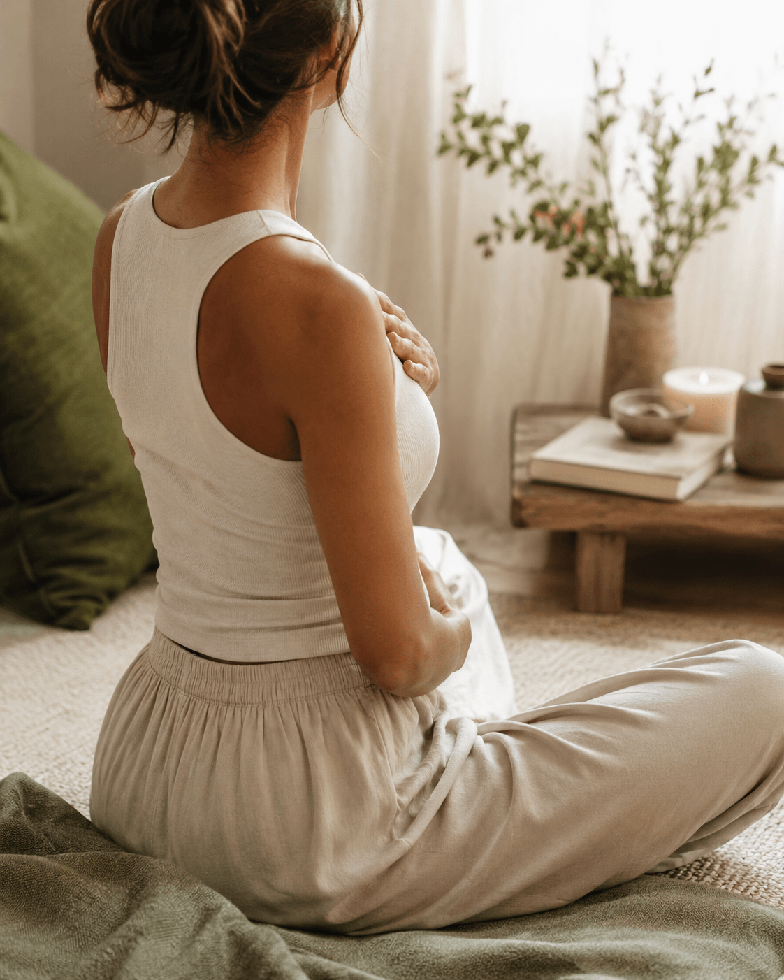Femme assise calmement avec les mains sur le cœur et le ventre pour illustrer le lien entre stress, corps et émotions