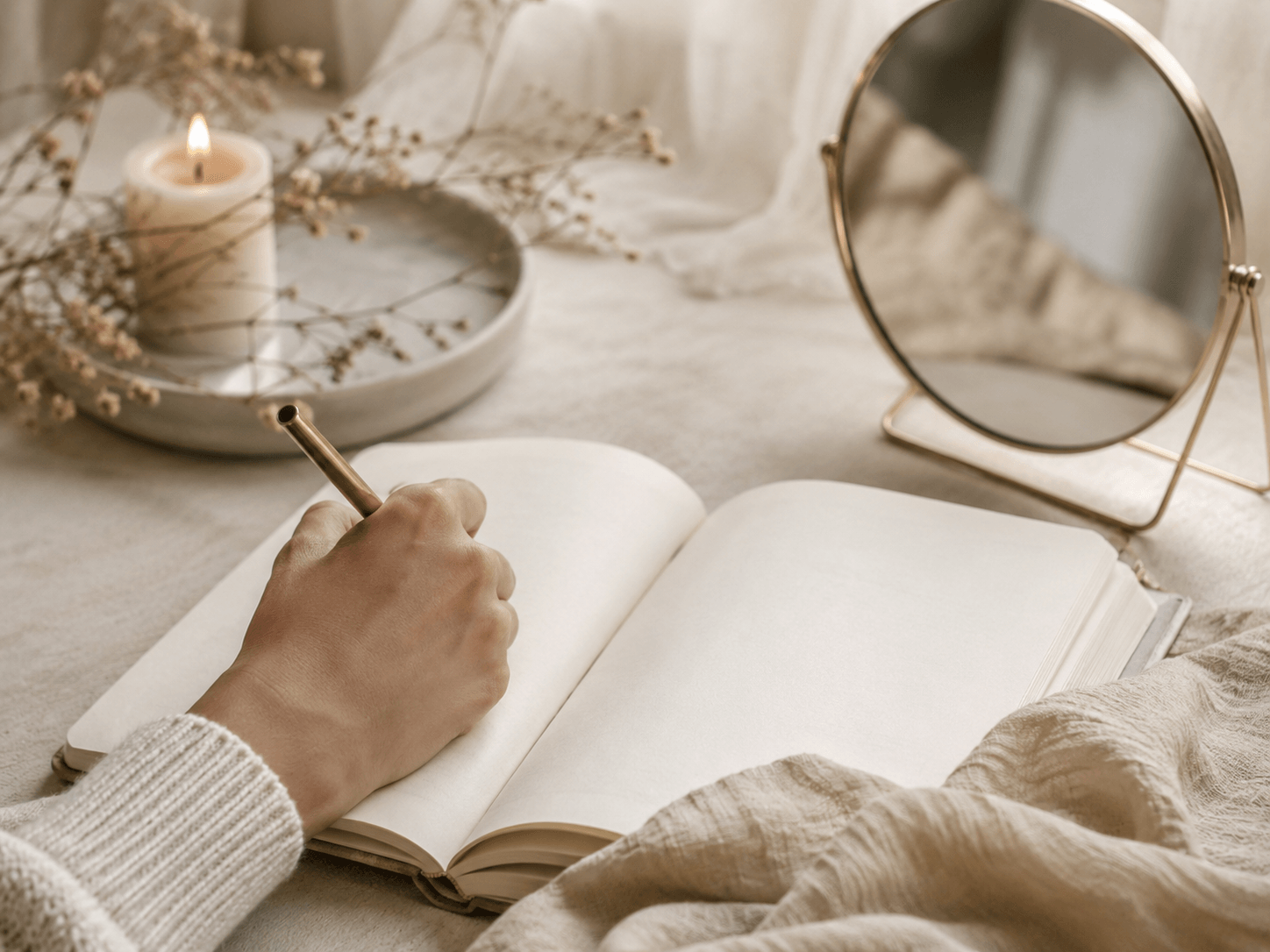 Main écrivant dans un carnet d’introspection avec un miroir discret, dans une ambiance douce et apaisante