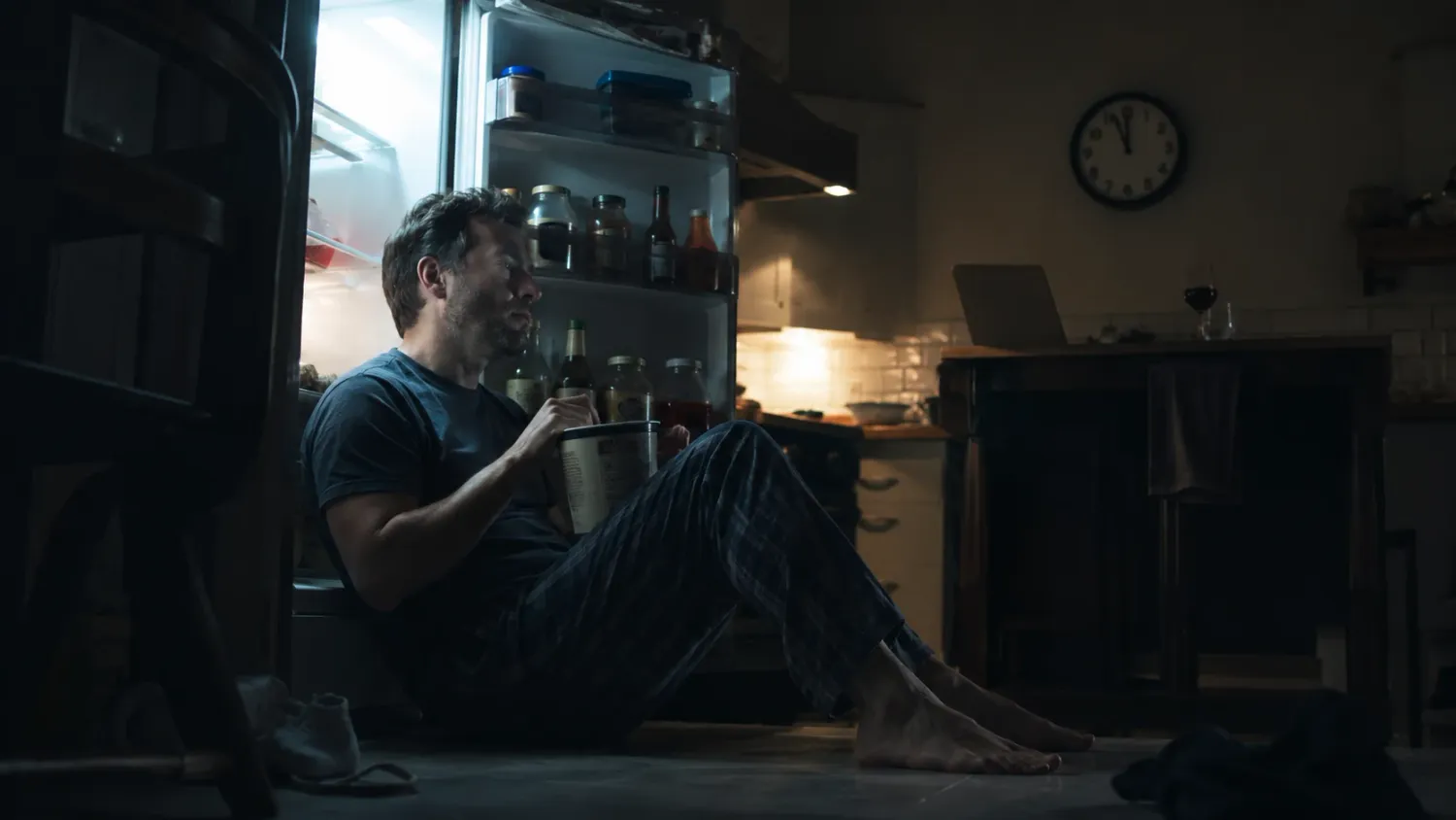 Man eating in front of fridge at night