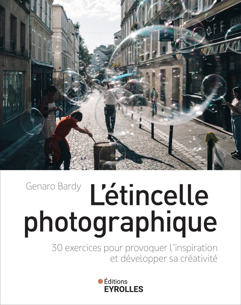 book cover photograph, giant soap bubbles floating in a sunlit narrow Paris street, child in red t-shirt blowing bubbles, cobblestones, warm backlight, documentary street photography, portrait orientation