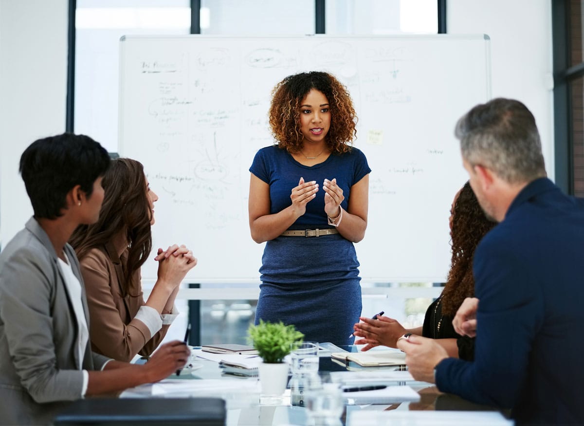 A woman standing up in a blue office dress,